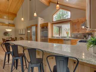 Experience rustic charm in this spacious kitchen featuring vaulted wood-paneled ceilings and exposed beams.