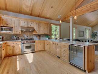 This spacious kitchen boasts beautiful natural wood cabinetry and a vaulted wood-paneled ceiling, creating a warm and inviting atmosphere.