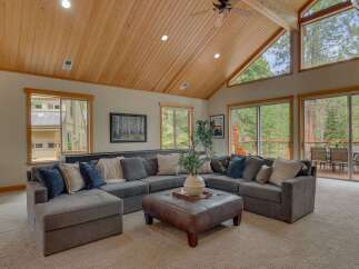 Experience luxurious living in this stunning mountain retreat, featuring a spacious sectional sofa perfect for gatherings and an elegant leather ottoman as a centerpiece.
