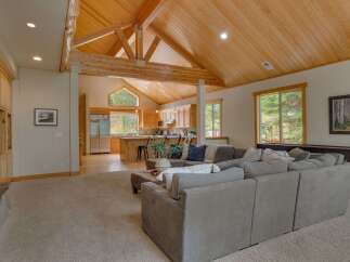 Experience rustic charm and modern comfort in this open-concept living space, featuring a vaulted wood-beamed ceiling and a gourmet kitchen with ample cabinetry.
