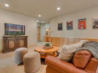 This cozy living room features a large flat-screen TV mounted on a rustic wooden cabinet, perfect for movie nights.