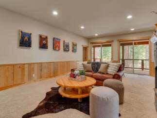 This inviting living room features a plush leather sofa, a rustic wooden coffee table, and a cozy stone fireplace, perfect for gathering with loved ones.