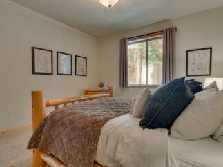 Experience rustic charm in this cozy bedroom, featuring a sturdy log bed and a plush, textured comforter.
