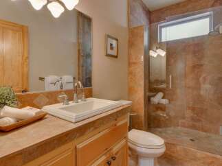 Experience luxury in this beautifully appointed bathroom, featuring a spacious walk-in shower with elegant marble tile and a sleek glass enclosure.