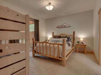 Experience rustic charm in this cozy bedroom featuring a beautiful log bed and warm, inviting decor.