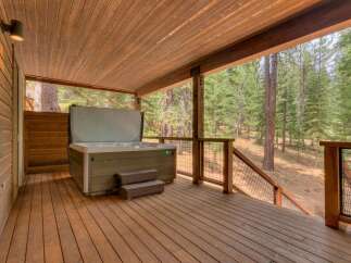 Enjoy ultimate relaxation in this stunning property featuring a luxurious hot tub on a spacious wooden deck.
