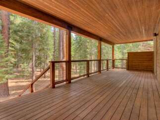 Experience the ultimate indoor-outdoor living with this expansive wooden deck, perfect for entertaining or simply enjoying the serene forest views.