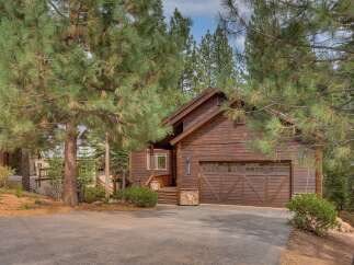 Nestled amongst tall pine trees, this charming wooden cabin offers a serene mountain retreat.