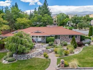 Discover this charming brick home featuring a durable tile roof and a beautifully landscaped yard.