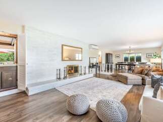 Experience elegant living in this spacious open-concept home, featuring a stunning white brick fireplace as the centerpiece of the living area.