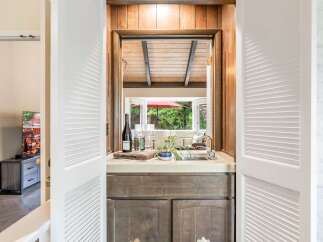 Discover this charming wet bar, perfect for entertaining, featuring a stainless steel sink and ample counter space.