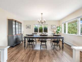 This elegant dining room features a dark wood dining table with six matching chairs, perfect for hosting family gatherings.
