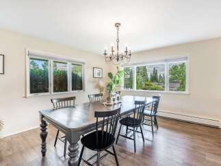 This dining room features a large wooden table with six chairs, perfect for family gatherings.