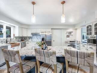 This spacious kitchen boasts a large granite island with seating, perfect for casual dining and entertaining.