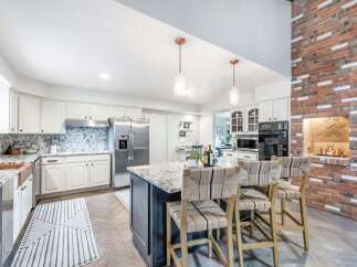 This spacious kitchen boasts white shaker cabinets, granite countertops, and a large island perfect for entertaining.