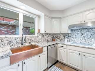 Experience the charm of this beautifully updated kitchen, featuring a stunning copper farmhouse sink and elegant granite countertops.