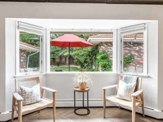 Enjoy the natural light and serene backyard views from this charming bay window seating area.