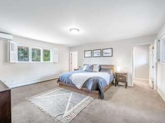 Experience comfort and style in this spacious master bedroom, featuring a king-sized bed adorned with plush bedding and decorative pillows.