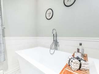 Indulge in relaxation with this luxurious freestanding bathtub, featuring a sleek chrome faucet and a convenient handheld showerhead.