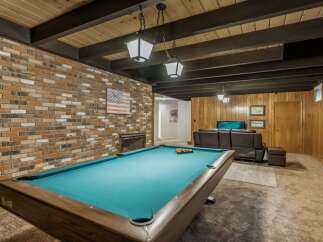 Enjoy endless entertainment in this finished basement, featuring a full-size pool table perfect for game nights.