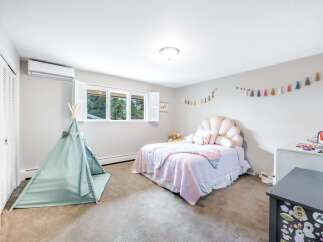 This charming children's bedroom features a playful teepee and a whimsical seashell-shaped headboard on the bed.