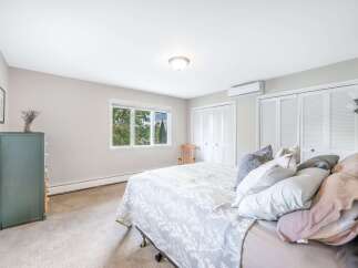 Discover comfort and style in this inviting bedroom, featuring a spacious bed adorned with plush pillows and a charming floral-patterned comforter.