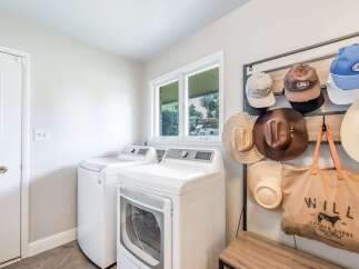 This laundry room offers ample space with a washer and dryer set, perfect for handling household chores efficiently.
