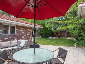 Enjoy outdoor living with this spacious patio featuring a comfortable sectional sofa and a glass-top dining table, perfect for al fresco meals.