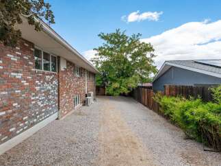 Discover this charming property featuring a durable brick exterior and a spacious gravel driveway, perfect for easy access and parking.