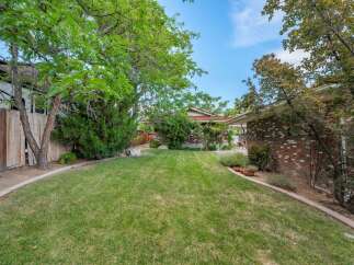 Enjoy this spacious backyard with a lush green lawn, perfect for outdoor activities and relaxation.