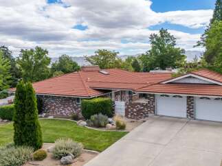 Discover this charming brick home featuring a durable red tile roof and a spacious three-car garage.