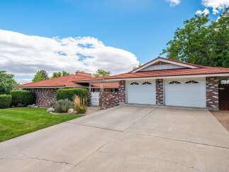 Discover this charming brick home featuring a durable red tile roof and a spacious two-car garage.
