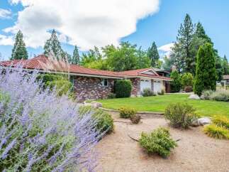 Discover this charming brick home featuring a durable tile roof and a spacious three-car garage, perfect for vehicles and storage.