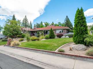 Discover this charming brick ranch home featuring a durable tile roof and a beautifully landscaped yard.
