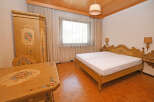 Charming bedroom featuring a beautifully ornate, hand-painted wardrobe and matching bedside tables.