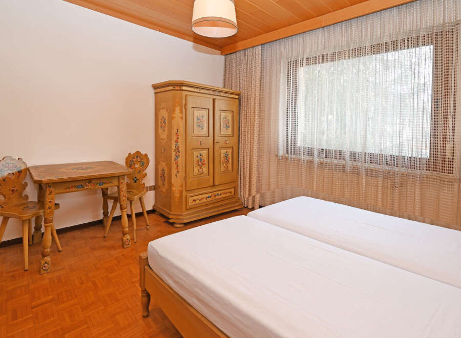 Experience rustic charm in this cozy bedroom featuring two twin beds dressed in crisp white linens.