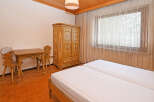 Experience rustic charm in this cozy bedroom featuring two twin beds dressed in crisp white linens.
