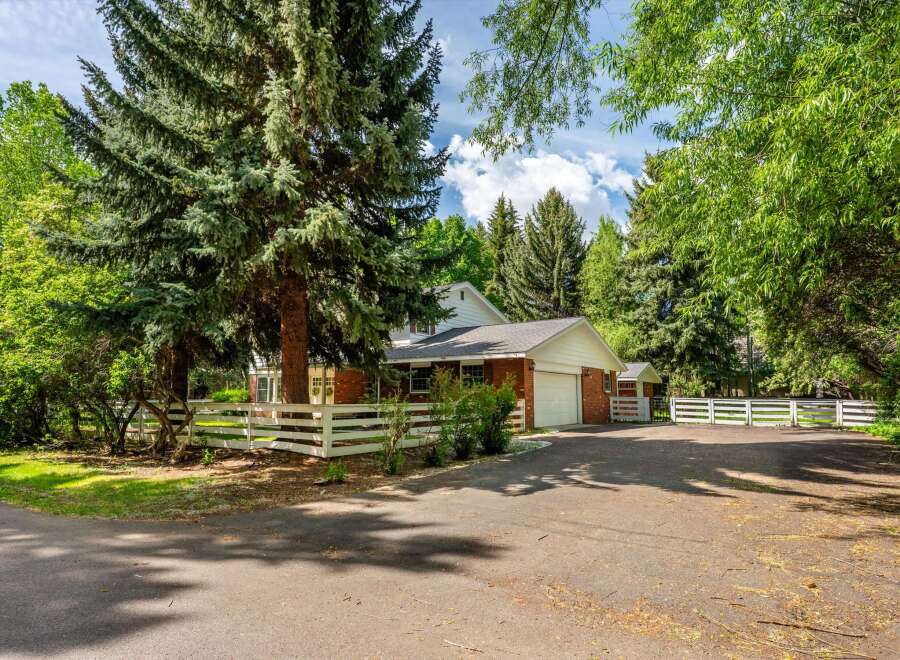 Nestled amidst mature trees, this charming brick home offers a serene retreat.