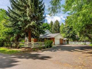 Nestled amidst mature trees, this charming brick home offers a serene retreat.