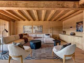 Experience rustic luxury in this stunning mountain retreat, featuring exposed wooden beams and warm wood paneling throughout.