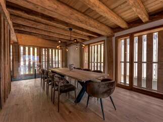Experience rustic luxury in this stunning dining room, featuring a live-edge wooden table and plush velvet chairs.