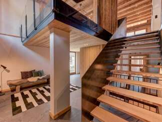 Experience luxury mountain living in this stunning chalet featuring a modern open-concept design with natural wood accents throughout.