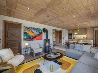 Experience luxury mountain living in this stunning chalet, featuring a modern open-plan living area with a cozy fireplace and a fully equipped kitchen.