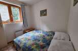 This cozy bedroom features a comfortable double bed adorned with a vibrant floral duvet, perfect for a restful night's sleep.