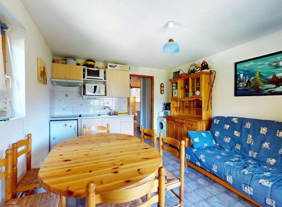 This charming studio apartment features a well-equipped kitchenette and a cozy dining area perfect for meals.