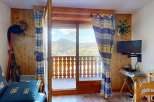 Experience breathtaking mountain views from this charming property, featuring a cozy living space with wooden accents and a private balcony perfect for enjoying the scenery.