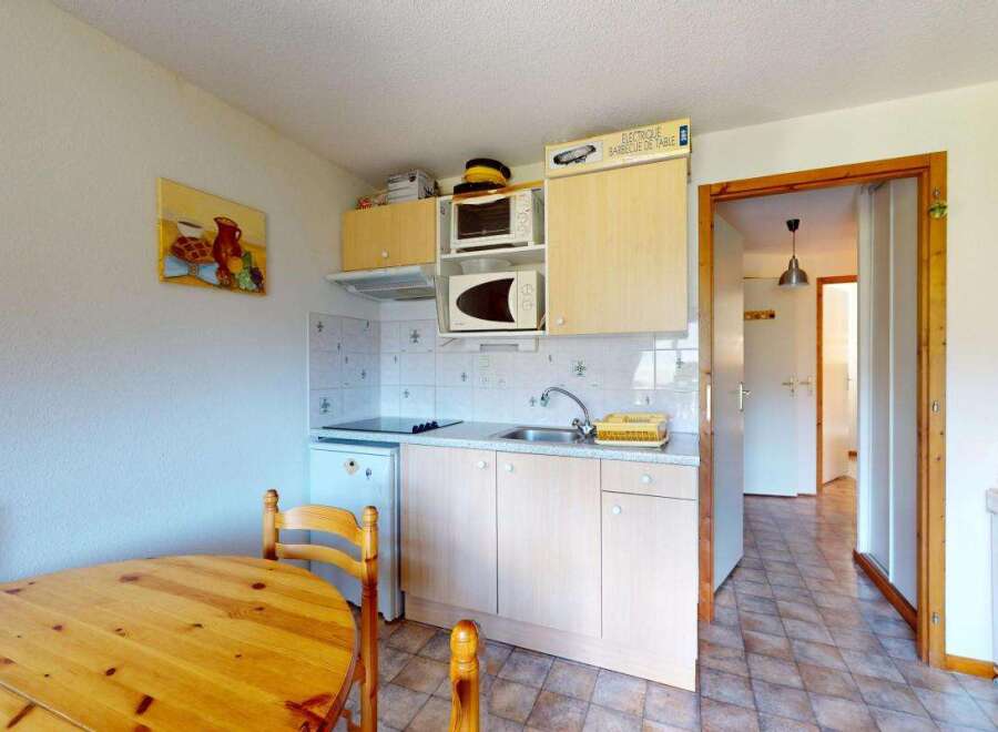 This charming kitchen features a compact dining area with a wooden table and chairs, perfect for intimate meals.