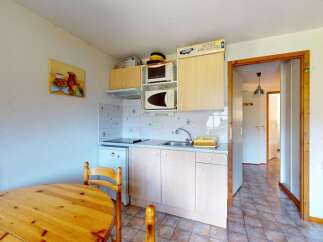 This charming kitchen features a compact dining area with a wooden table and chairs, perfect for intimate meals.