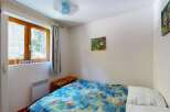 Discover this charming bedroom featuring a comfortable bed adorned with a vibrant, nature-inspired duvet.