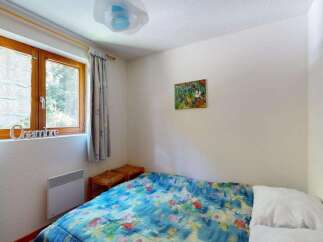 Discover this charming bedroom featuring a comfortable bed adorned with a vibrant, nature-inspired duvet.